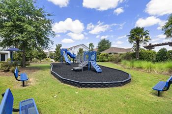 Playground at a park with a slide and a black trampoline